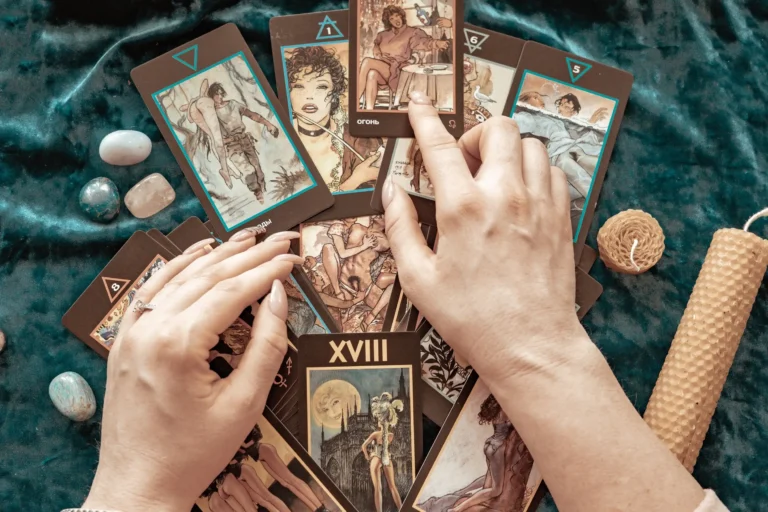 A table with tarot cards read by the fortune teller's hands.
